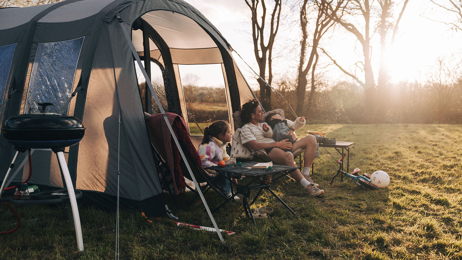 A men with his two young children having a camping trip with their Kampa tent