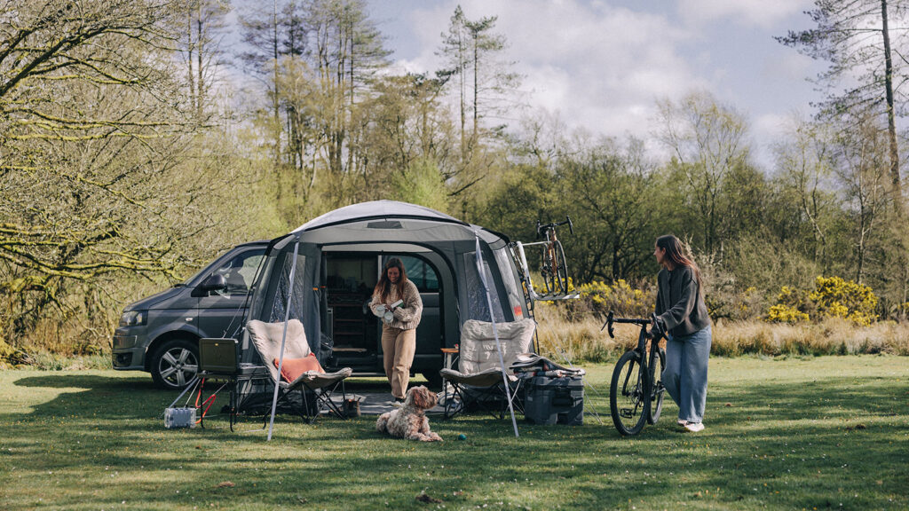 A couple enjoying a Kampa drive away tent with their dog