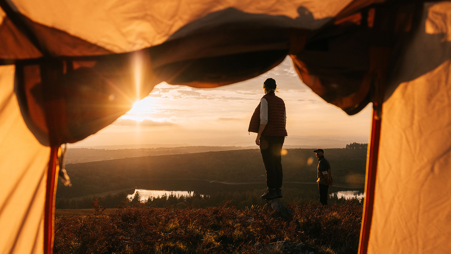 A couple watching a sunset from their Kampa tent